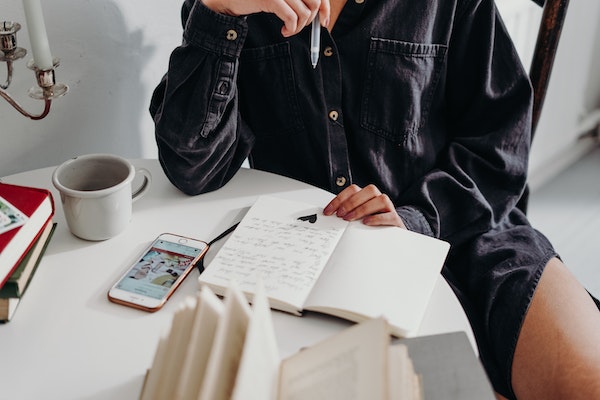 A Person Using A Journal To Avoid Mental Block