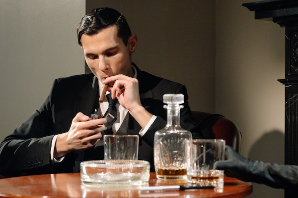 A Guy Smoking While Drinking Alcohol