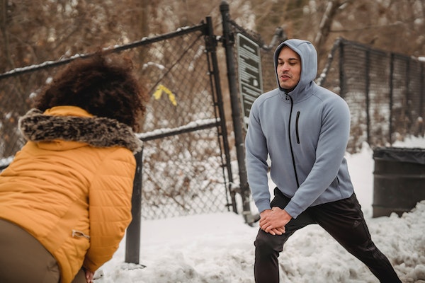 A Couple Doing Hip Stretches To Run Better