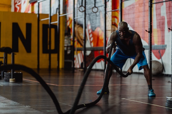 A Man Doing Battle Ropes To Increase His Grip Strength