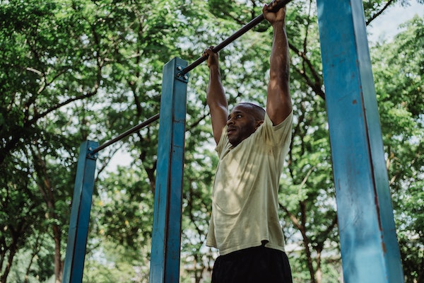 A Man Doing Dead Hangs To Improve His Grip Strength