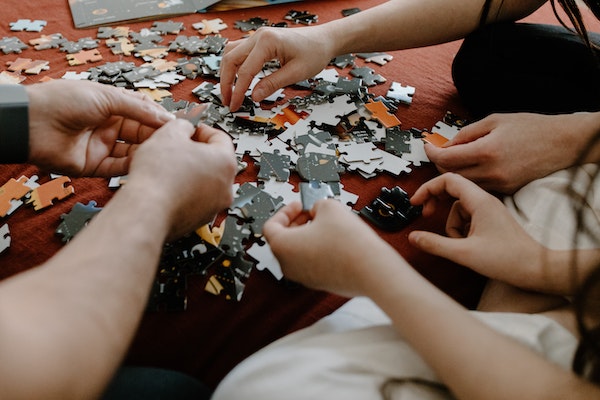 A Group Of People Solving A Puzzle