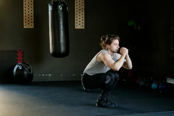 man in gray tank top doing squats