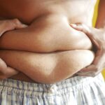 a person holding on to belly fat
