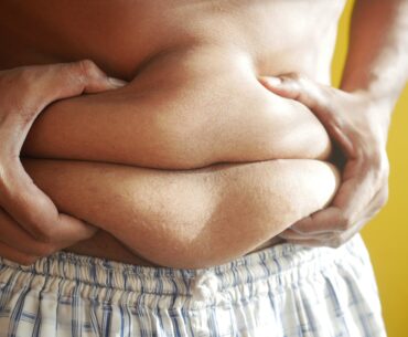 a person holding on to belly fat
